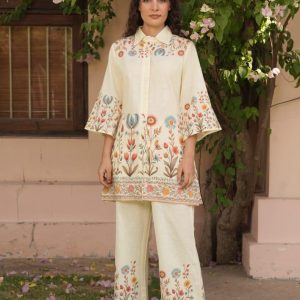 Woman wearing cream co-ord set with colorful floral embroidery