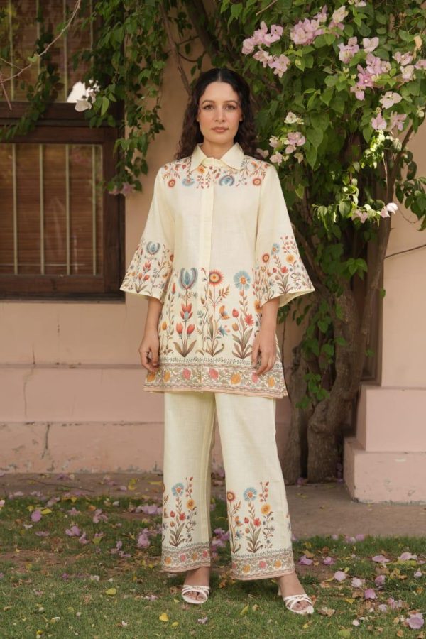 Woman wearing cream co-ord set with colorful floral embroidery