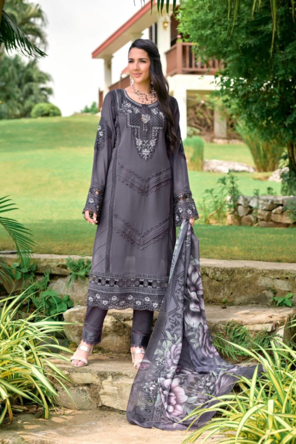Elegant woman wearing charcoal grey embroidered 3-piece suit with floral printed dupatta, standing in a lush garden – The Elegance Corner