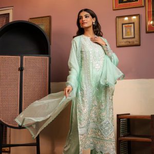 Woman wearing a mint green embroidered ready-made suit with intricate floral Chikankari work, paired with matching dupatta and pants, ideal for formal and casual wear.
