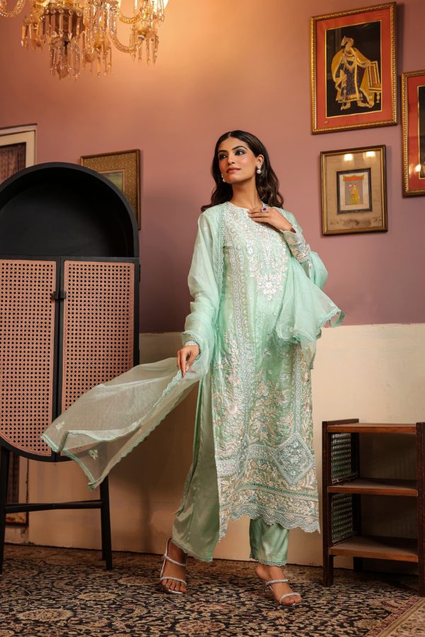 Woman wearing a mint green embroidered ready-made suit with intricate floral Chikankari work, paired with matching dupatta and pants, ideal for formal and casual wear.